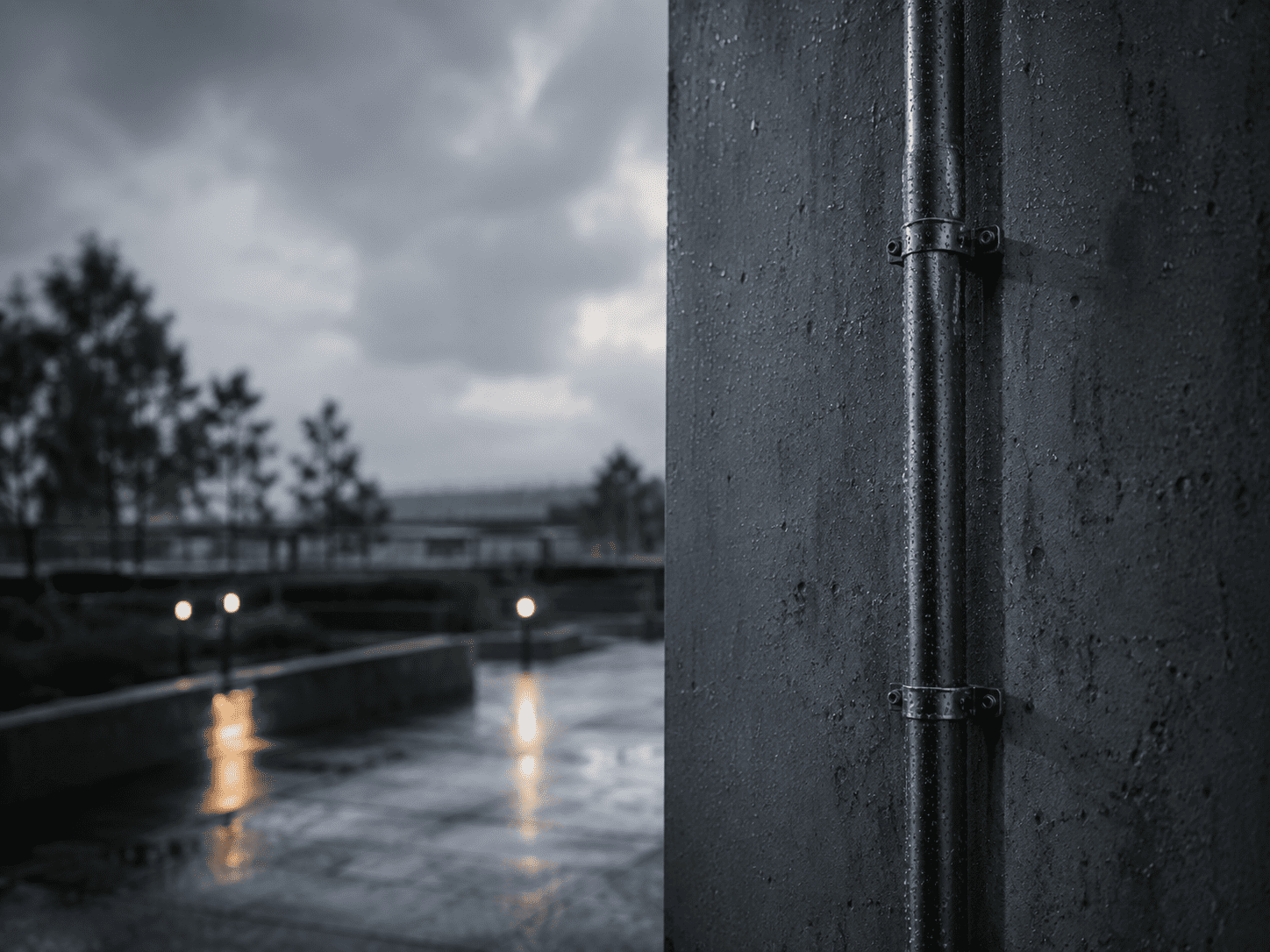 Regennasse Außeninstallation mit Betonwand und Installationsrohr